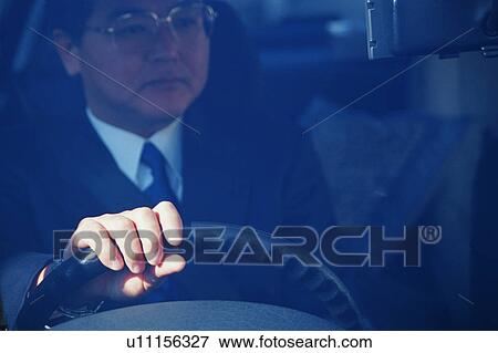 Stock Photo - Front view of a mature man inside a car. Fotosearch