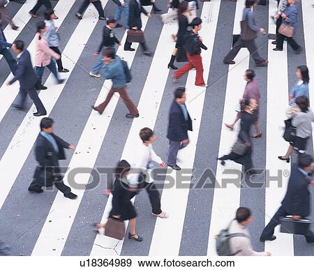 Stock Photo - Large group of people walking on zebra crossing. Fotosearch
