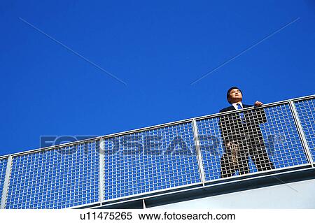 Low angle view of a mature man standing near railing View Large Photo Image Stock Photography - Low angle view of a mature man standing near railing. Fotosearch