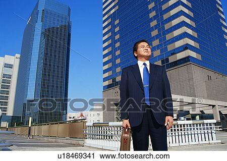 Mature man in suit standing in front of buildings View Large Photo Image Stock Image - Mature man in suit standing in front of buildings. Fotosearch