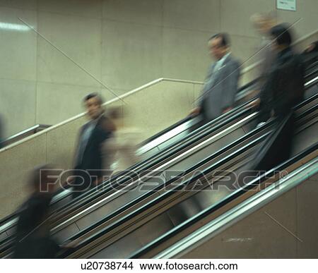 Picture - Medium group of people in office wear on escalator. Fotosearch
