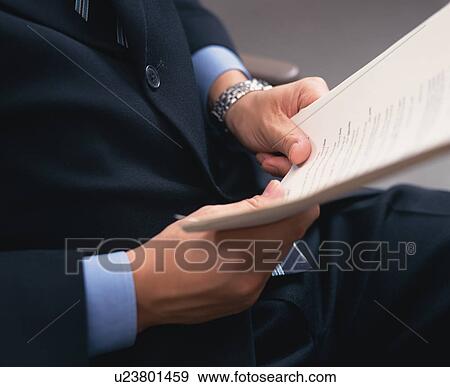 Midsection of a person holding certain office documents View Large Photo Image Stock Photo - Midsection of a person holding certain office documents. Fotosearch