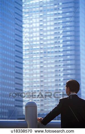 Stock Image - Rear view of a mature man staring at office. Fotosearch