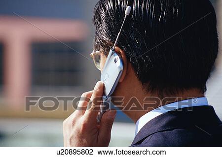 Stock Image - Rear view of a mature man talking on cell phone. Fotosearch