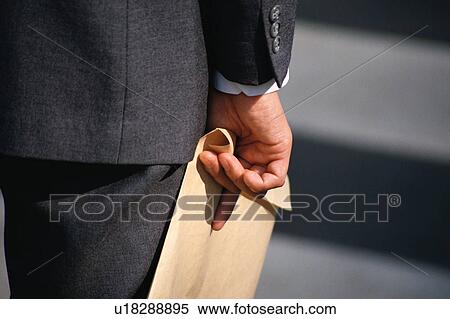 Stock Photography - Rear view of a person holding a brown cover. Fotosearch