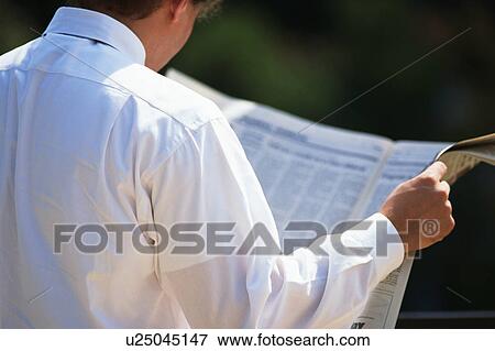 Rear view of a person reading newspaper View Large Photo Image Stock Photo - Rear view of a person reading newspaper. Fotosearch
