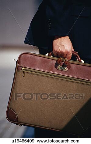 Side view of a person holding an office bag View Large Photo Image Stock Photo - Side view of a person holding an office bag. Fotosearch