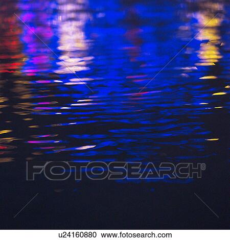 Stock Image - Colorful lights reflected on water surface. Fotosearch