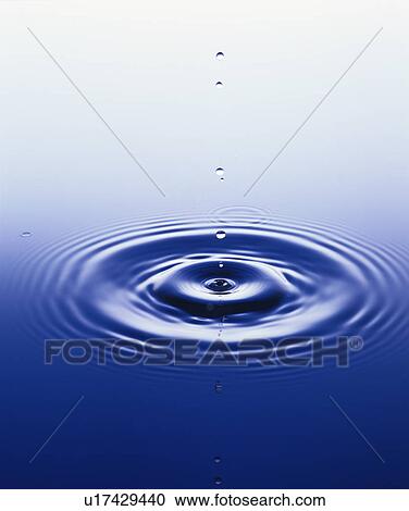 Stock Image - Water droplet falling on surface of water . Fotosearch