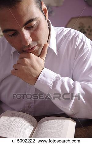 Young man reading a book View Large Photo Image Stock Image - Young man reading a book. Fotosearch