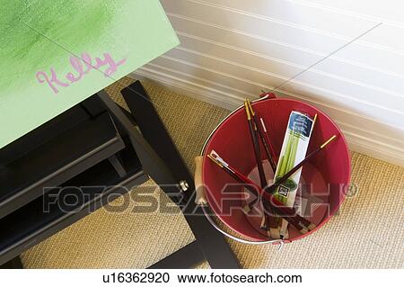 Stock Image - Art easel with paint brushes. Fotosearch