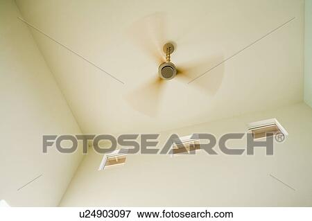Modern Ceiling Fan With Wood Blades In Motion Stock Photo