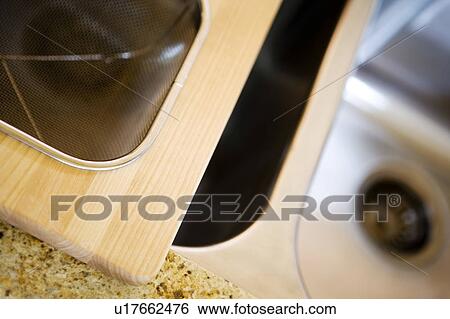 Cutting board, strainer sitting on kitchen sink View Large Photo Image Stock Photograph - Cutting board, strainer sitting on kitchen sink. Fotosearch