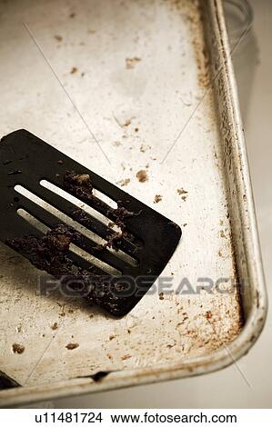 Picture - Detail of a dirty spatula on a dirty cookie sheet. Fotosearch