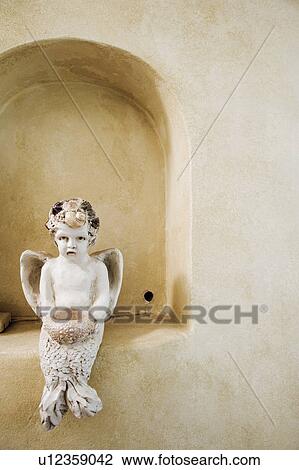 Stock Image - Detail of angel statue in arch.. Fotosearch