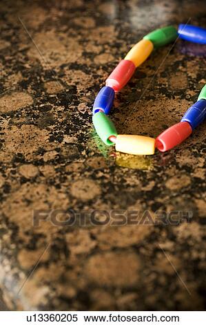 Stock Photography - Detail of child's bracelet on a granite countertop. Fotosearch
