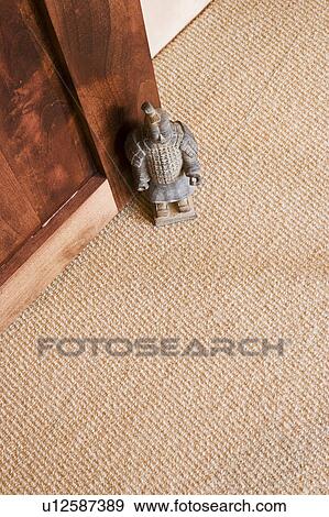 Stock Photo - Detail of small samurai statue propping a door open. Fotosearch