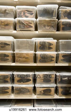 Stock Image - Dress shoes organized in plastic storage boxes.. Fotosearch