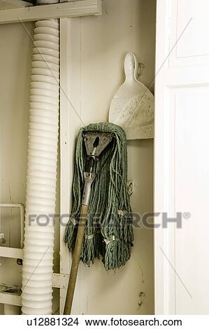 Picture - Janitorial mop and dustpan in white closet. Fotosearch