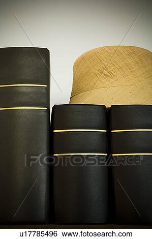 Stock Photograph - Straw hat on black photo albums. Fotosearch