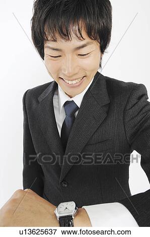 Businessman to see a wristwatch View Large Photo Image Stock Photo - Businessman to see a wristwatch. Fotosearch