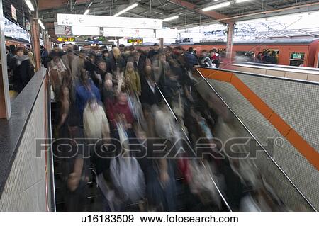 Stock Photo - Group of people descending steps in station. Fotosearch