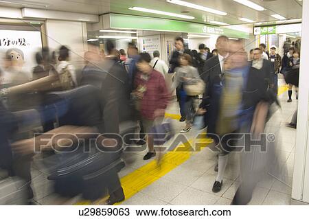 Stock Image - People walking in a station. Fotosearch