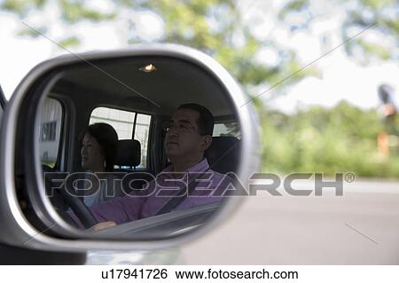 Stock Photograph - Mature couple reflected on side-view mirror. Fotosearch