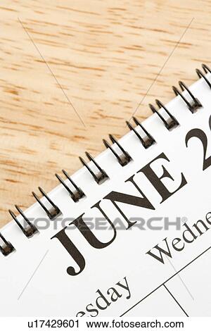 Stock Image - Close up of spiral bound calendar displaying month of June. Fotosearch
