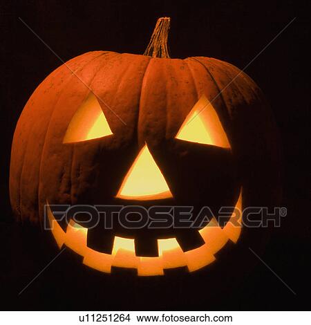 Picture - Carved Halloween pumpkin glowing in the dark.. Fotosearch