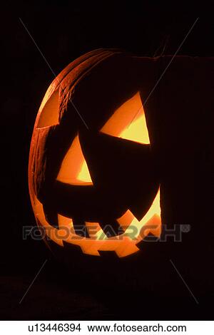 Carved Halloween pumpkin glowing in the dark. View Large Photo Image Picture - Carved Halloween pumpkin glowing in the dark.. Fotosearch