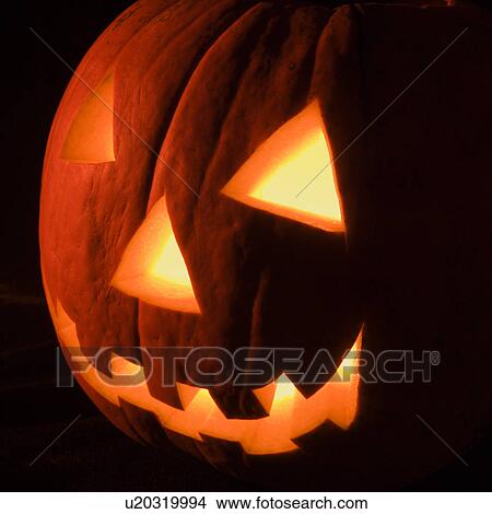 Picture - Carved Halloween pumpkin glowing in the dark.. Fotosearch
