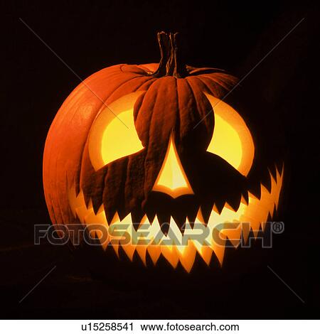 Carved Halloween pumpkin glowing in the dark. View Large Photo Image Stock Image - Carved Halloween pumpkin glowing in the dark.. Fotosearch