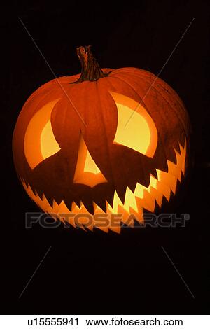 Carved Halloween pumpkin glowing in the dark. View Large Photo Image Stock Image - Carved Halloween pumpkin glowing in the dark.. Fotosearch
