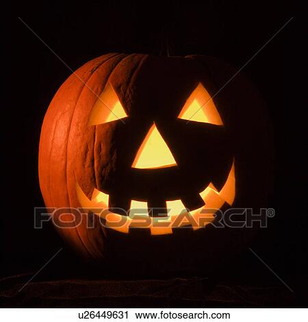 Stock Image - Carved Halloween pumpkin glowing in the dark.. Fotosearch