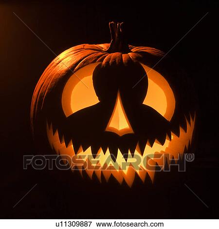 Carved Halloween pumpkin glowing in the dark. View Large Photo Image Stock Photo - Carved Halloween pumpkin glowing in the dark.. Fotosearch