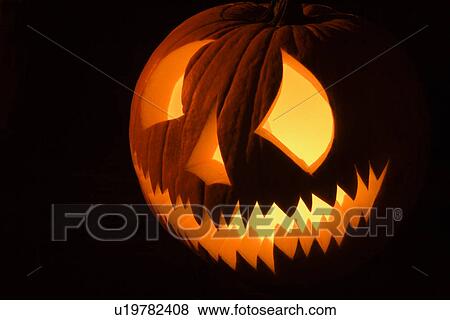 Carved Halloween pumpkin glowing in the dark. View Large Photo Image Stock Photo - Carved Halloween pumpkin glowing in the dark.. Fotosearch