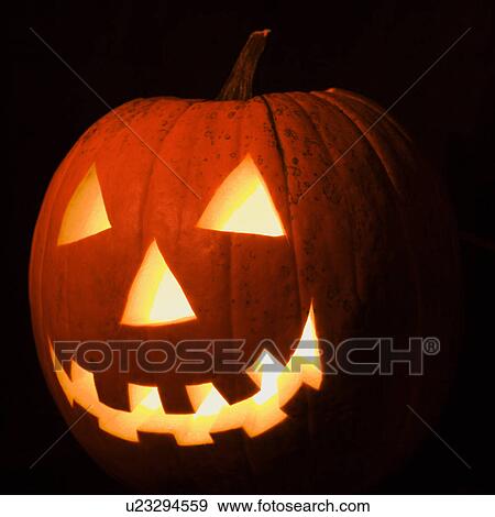 Carved Halloween pumpkin glowing in the dark. View Large Photo Image Stock Photo - Carved Halloween pumpkin glowing in the dark.. Fotosearch