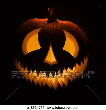 Carved Halloween pumpkin glowing in the dark. View Large Photo Image Stock Photograph - Carved Halloween pumpkin glowing in the dark.. Fotosearch