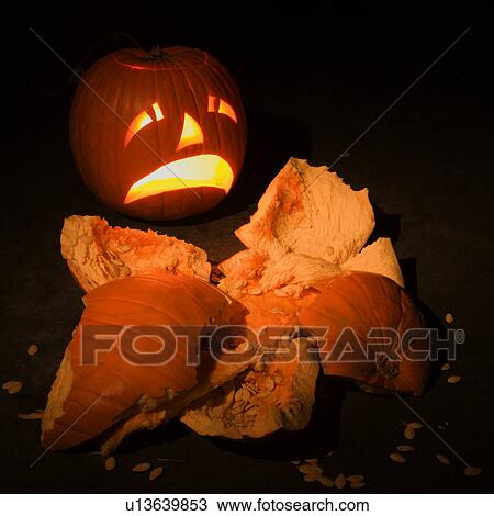 Stock Image - Upset jack-o'-lantern looking at smashed pumpkin.. Fotosearch