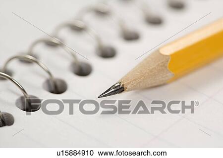 Stock Image - Close up of pencil on top of spiral bound notebook. Fotosearch