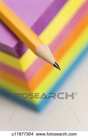Picture - Close up of sharp pencil on stack of colorful sticky notes. Fotosearch