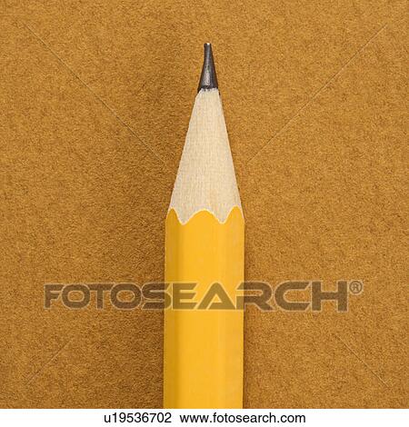 Stock Image - Close up of sharp pencil tip on tan background.. Fotosearch