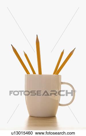 Stock Image - Five pencils in a coffee cup with pointed ends up. Fotosearch