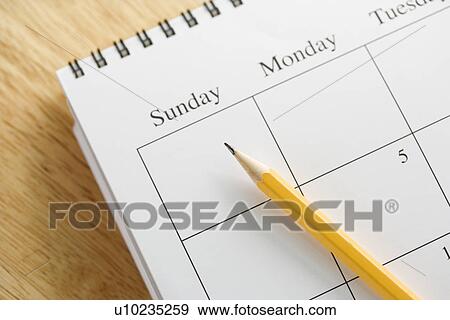 Stock Photo - Pencil on top of a spiral bound calendar. Fotosearch