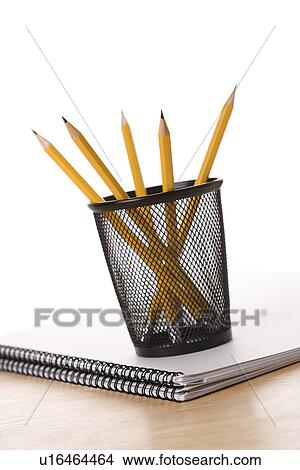 Picture - Pencils in pencil holder on top of spiral bound notebook. Fotosearch