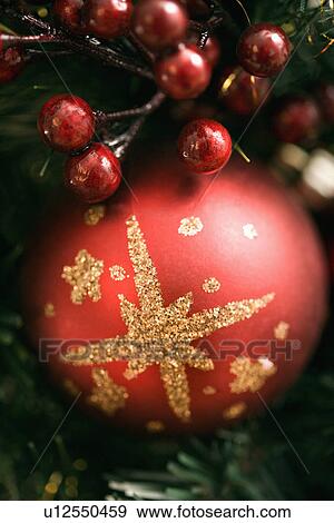 Stock Photo - Close up of red ornament and berries on Christmas wreath.. Fotosearch