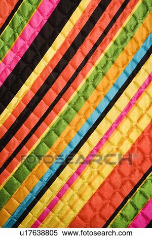Stock Photography - Close-up of bright colorful striped quilted vintage fabric. Fotosearch