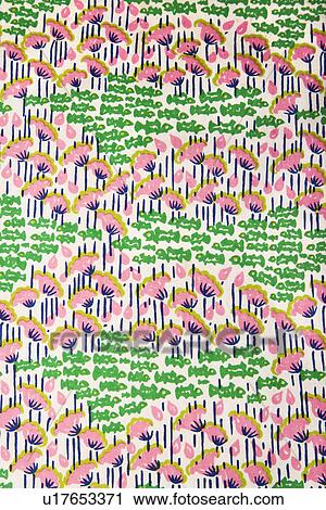 Stock Image - Close-up of vintage fabric with pink flowers and green fish printed on polyester. Fotosearch