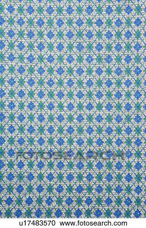 Stock Image - Close-up of woven vintage fabric with repetitive blue and green diamonds. Fotosearch